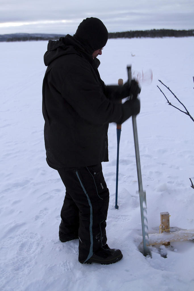 Sawing a hole in the ice to retrieve the net